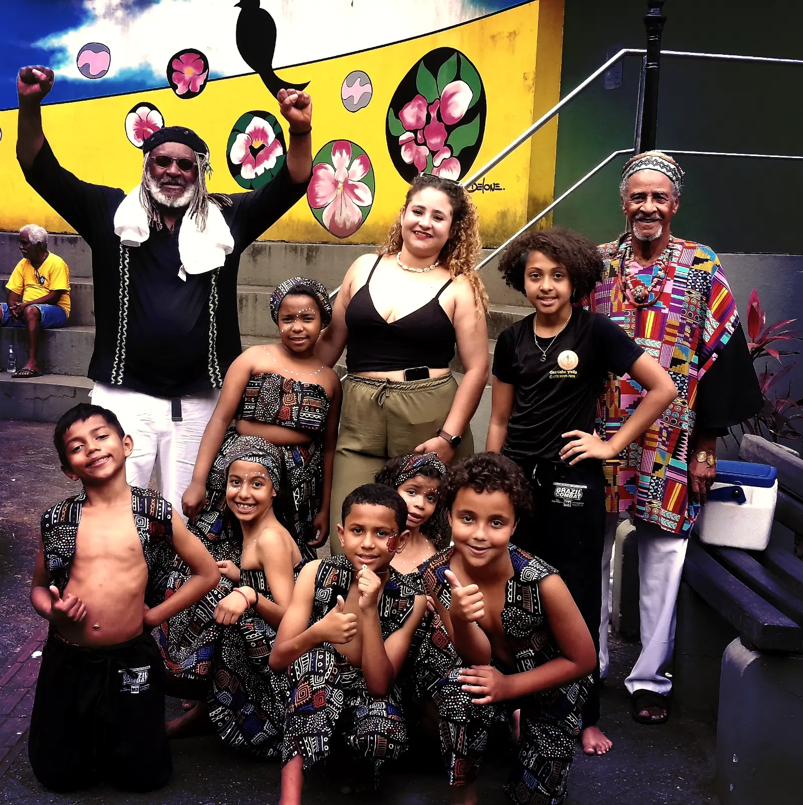 Circulação Pai Felipe - Foto 08 Artistas e crianças celebrando uma apresentação.